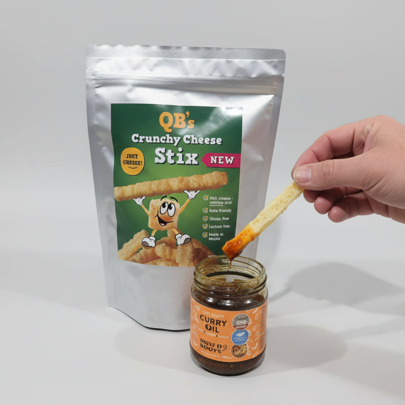 Person dipping a QB's Crunchy Cheese Stix into a jar of hot Stuff next to a package of the Stix.