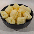 Close-up of QB’s Crunchy Cheese pieces in a bowl showing the light, crunchy texture of 100% real NZ cheese.